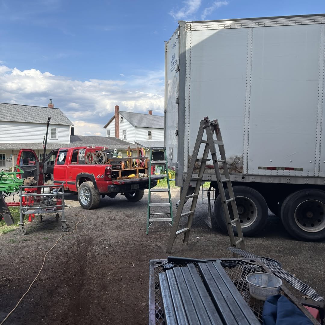 JT Mobile Welding service truck and trailer set up on a job site with steel stock laid out